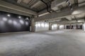 Empty interior of large concrete room as warehouse or hangar with spotlights Royalty Free Stock Photo