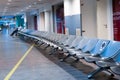 Empty international airport building during pandemic. Empty seat rows at airport lounge