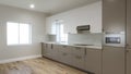 Long kitchen with a large refrigerator and a window over the sink. 3d render Royalty Free Stock Photo