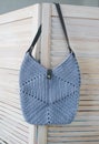 Empty knitted bag hanging on wooden door. Ad and buy concept Royalty Free Stock Photo