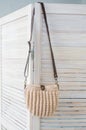 Empty knitted purse hanging on wooden door. Ad and buy concept