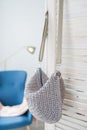 Empty knitted purse hanging on wooden door