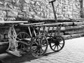 Old ladder car in front of a stone wall with wooden beams in front in black and white