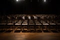 an empty large concert hall with black chairs