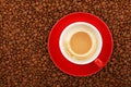 Empty latte in red cup and saucer on coffee beans Royalty Free Stock Photo