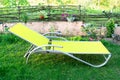 Empty lawn chair, lounge on green grass in garden, backyard in summer vacation, relaxation, sunbathing time Royalty Free Stock Photo