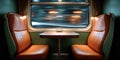 Interior view of a vintage train compartment with two empty leather seats and a wooden table by a window showing blurred motion Royalty Free Stock Photo
