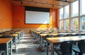 Empty lecture hall with rows of tables and chairs. A large projector screen is on the orange wall. Big windows show autumn trees Royalty Free Stock Photo