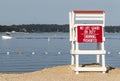 Empty lifeguard stand looking over the calm bay with a boat in the background Royalty Free Stock Photo