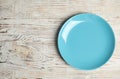 Empty light blue plate on white wooden table, top view. Space for text Royalty Free Stock Photo