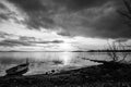 An empty little boat in Trasimeno lake Umbria, Italy at sunset, near skeletal plants