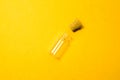 Empty little bottle with cork stopper isolated on yellow. transparent container. test tube Royalty Free Stock Photo