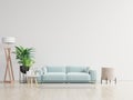 Empty living room with blue sofa  plants and table on empty white wall background Royalty Free Stock Photo