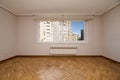 Empty living room with French oak parquet flooring arranged in a herringbone pattern, white aluminum windows with shutters and Royalty Free Stock Photo