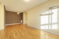 Empty living room with oak hardwood flooring, dark gray painted wall and two others in soft cream color Royalty Free Stock Photo