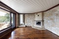 Empty living room with parquet, fireplace, windows and rock on the walls