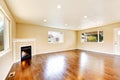 Empty living room with polished hardwood floor and corner fireplace. Royalty Free Stock Photo