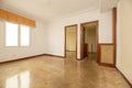 Empty living room of a residential house with French oak parquet flooring placed in herringbone, wood carpentry on the doors and