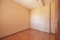 Empty living room with sapele wood interior doors with peach painted walls and parquet wood-like stoneware floors Royalty Free Stock Photo