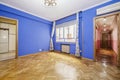 Empty living room with walls painted in chillo blue, French oak parquet floors laid in a herringbone pattern, access to several