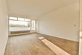 an empty living room with wood floors and a window Royalty Free Stock Photo