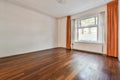 an empty living room with wood floors and a window Royalty Free Stock Photo