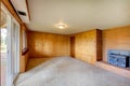 Empty living room with wood panel walls and cast iron fireplace Royalty Free Stock Photo