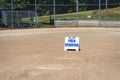 Empty local baseball field on a sunny day, view of pitcherÃ¢â¬â¢s mound, home plate and bleachers, Field Reserved sign
