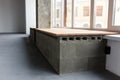 Empty loft room with wooden bench on gray bricks, close selective focus Royalty Free Stock Photo