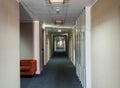 An empty long corridor as in a hospital at the end of bright sun shines through the window Royalty Free Stock Photo
