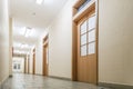 Empty long corridor. Empty office corridor with many doors of light wood