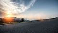 Empty long mountain road to the horizon on a sunny summer day at bright sunset Royalty Free Stock Photo