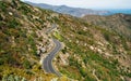 Empty long mountain road to the horizon on a sunny summer day at bright sunset Royalty Free Stock Photo