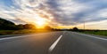 Empty long mountain road to the horizon on a sunny summer day at bright sunset