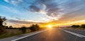 Empty long mountain road to the horizon on a sunny summer day at bright sunset Royalty Free Stock Photo