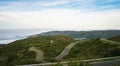 Empty long mountain road to the horizon on a sunny summer day at bright sunset