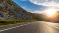 Empty long mountain road to the horizon on a sunny summer day at bright sunset Royalty Free Stock Photo