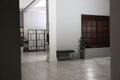 Empty long office corridor with bench and green potted plants