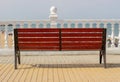 Empty low bench at the coast of the blue sea. An empty bench, rear view. Empty red bench, rear view. Bench, rear view Royalty Free Stock Photo
