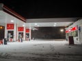 An empty Lukoil gas station on a winter night during heavy snowfall. Royalty Free Stock Photo