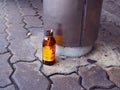 Empty M150 sport drink bottle on footpath floor, at bus stop