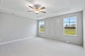 Empty master bedroom with gray walls, a ceiling fan, and windows Royalty Free Stock Photo