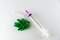 Empty medical syringe, needle and green pills Royalty Free Stock Photo