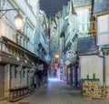 Empty medieval narrow street with closed stores illuminated in t