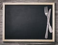 Empty menu blackboard with knife and fork on wooden background