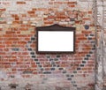 An empty message board hangs on the ruined brick wal