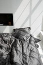 Empty messy dark gray bed with pillows in modern interior