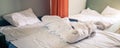 Empty messy untidy bed with white linen at morning time Royalty Free Stock Photo