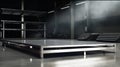 Empty metal platform for displaying products, blurred car workshop in background. Generative AI