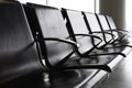 Empty metal seats with black leather seat in the public area at an airport